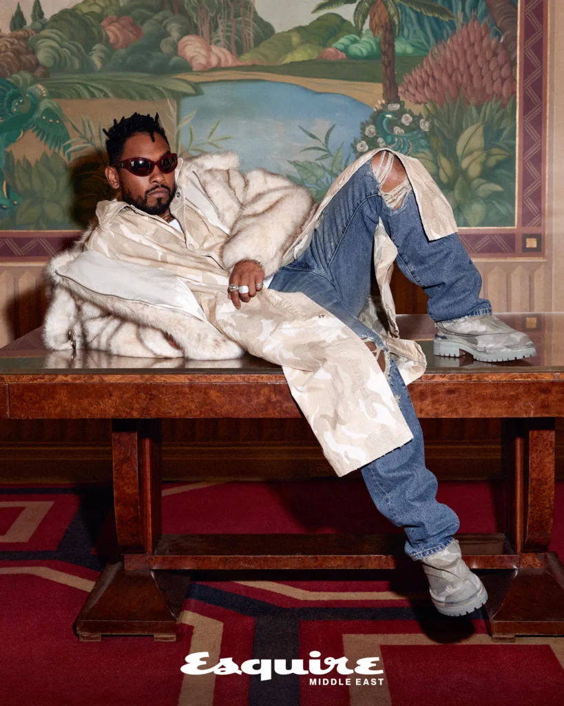 US Singer Miguel laying across a table wearing a fur coat
